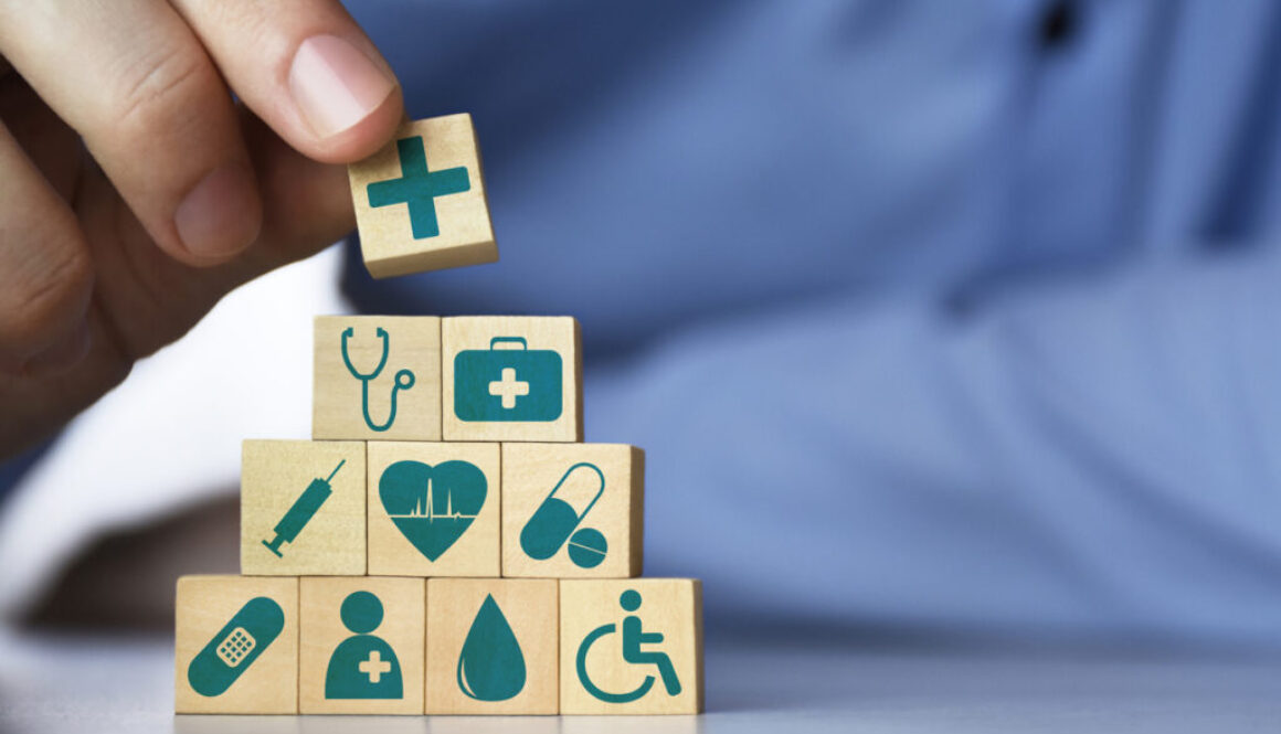 Medical health insurance concept. Men's hand arranging wood blocks with healthcare medicine icons