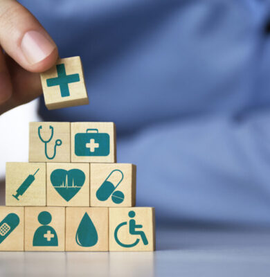 Medical health insurance concept. Men's hand arranging wood blocks with healthcare medicine icons