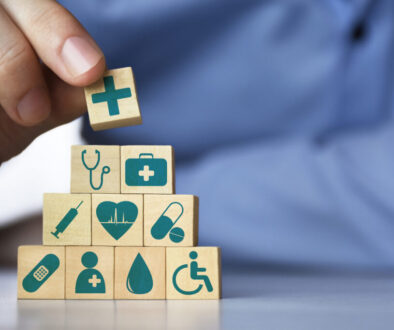 Medical health insurance concept. Men's hand arranging wood blocks with healthcare medicine icons